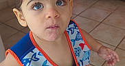 Yeshua is registered to the contest to win money with this photo: blue_eyes, casual, child, coca_cola, colorful_clothing, curious_expression, face, indoor, life_vest, person, portrait, sandals, shorts, small_hand, standing, tile_floor, toddler, vending_machine, wet_hair, young_child