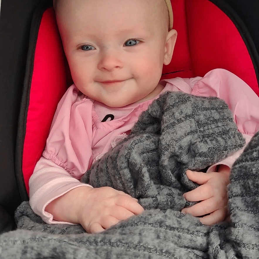 Nevaeh is registered to the contest to win money with this photo: accessories, baby, blanket, bodypart, clothing, crib, cushion, face, finger, furniture, hand, happy, hat, head, homedecor, newborn, person, photography, portrait, smile