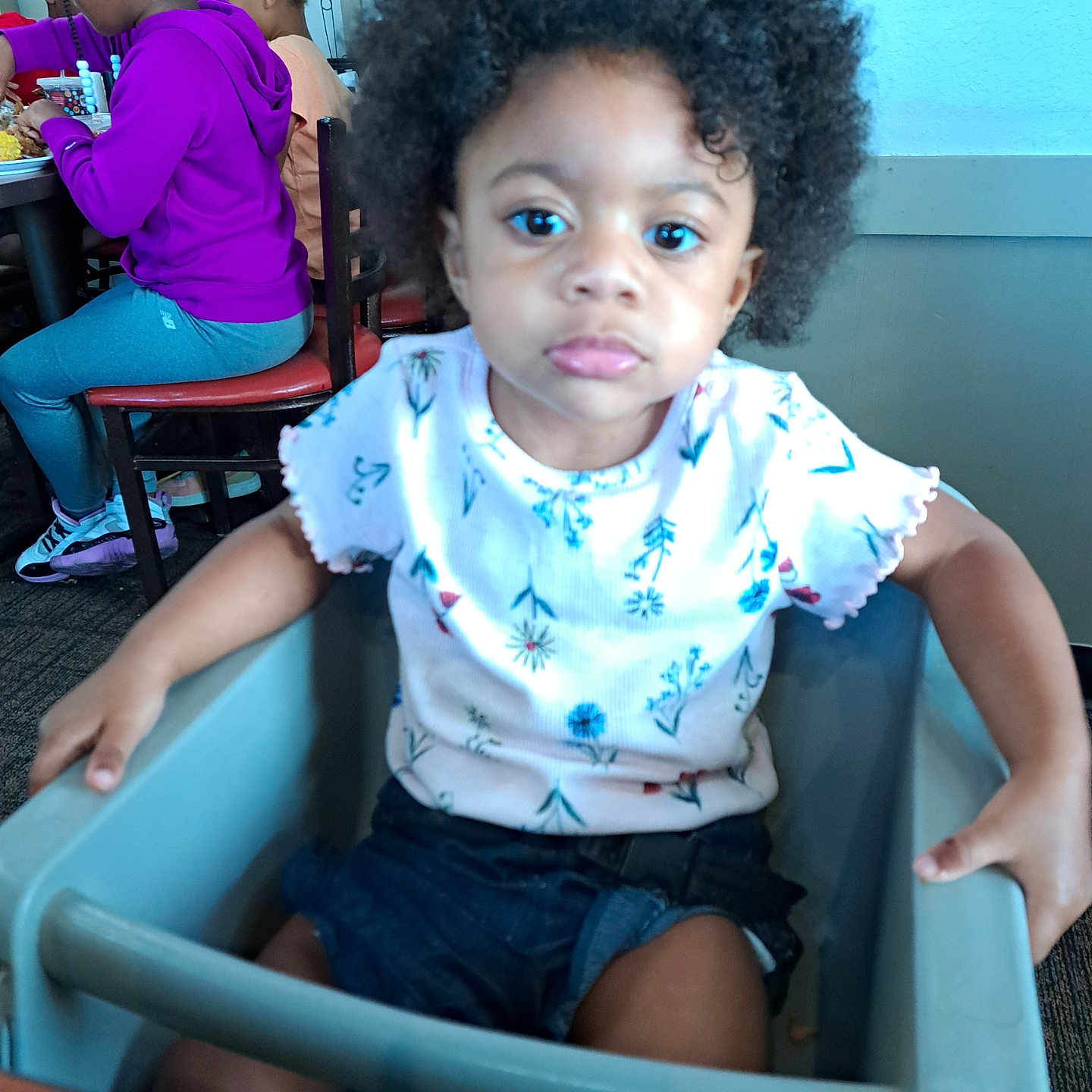 Laila is registered to the contest to win money with this photo: chair, child, clothing, couch, face, female, footwear, furniture, girl, head, indoors, pants, person, photography, portrait, restaurant, shoe, shorts, sitting, t_shirt