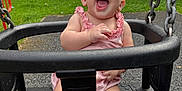 Winnie joined the competition — help win amazing prizes! baby, child, swing, playground, laughing, outdoor, greenery, pink_outfit, happy, seat, metal_chain, grass, bench, daylight, infant, fun, park, smiling, cute, joyful