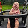baby, child, swing, playground, laughing, outdoor, greenery, pink_outfit, happy, seat, metal_chain, grass, bench, daylight, infant, fun, park, smiling, cute, joyful