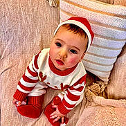 Rayan participe au concours pour gagner de l'argent avec cette photo : baby, beige, child, couch, cozy, cute, face, festive, holiday, indoors, infant, looking_up, pillow, portrait, red_hat, red_socks, sitting, soft_texture, striped_sweater, warm_colors