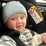 baby, child, car_seat, hat, knit_hat, smile, happy, face, blue_eyes, clothing, seatbelt, striped_sweater, cozy, indoor, portrait, infant, cute, warm, car, seat