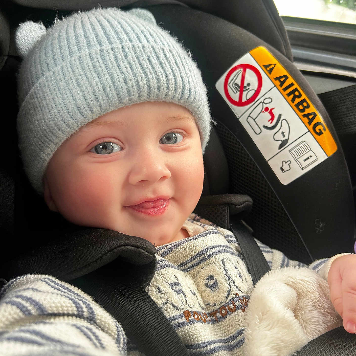 Isaya participe au concours pour gagner de l'argent avec cette photo : baby, child, car_seat, hat, knit_hat, smile, happy, face, blue_eyes, clothing, seatbelt, striped_sweater, cozy, indoor, portrait, infant, cute, warm, car, seat