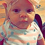 Brooklyn is registered to the contest to win money with this photo: baby, infant, headband, bow, pink, onesie, polka_dots, striped_clothing, face, eyes, hand, wooden_floor, indoor, child, portrait, cute, apparel, headwear, person, closeup