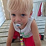 child, toddler, blonde_hair, blue_eyes, pacifier, beads, crawling, wooden_deck, white_tank_top, red_pants, outdoor, curious, baby, infant, face, person, clothing, floor, toy, closeup