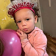 Lanaya is registered to the contest to win money with this photo: child, toddler, birthday, headband, balloon, pink, curly_hair, earrings, hoodie, indoor, wooden_floor, wall, person, clothing, cute, portrait, celebration, holding, standing, expression