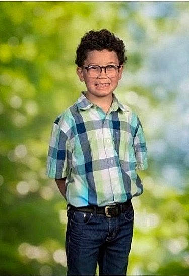 Ta'Vion joined the competition — help win amazing prizes! belt, blue_background, boy, casual, child, clothing, confident, curly_hair, glasses, green_background, hands_behind_back, happy, jeans, outdoor_background, plaid_shirt, portrait, short_sleeves, smiling, standing, young