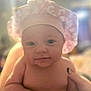 adorable, baby, child, chubby, closeup, cute, expression, face, hand, headwear, human, indoors, infant, newborn, person, pink_shower_cap, portrait, skin, smile, soft_light