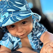 Apollo joined the competition — help win amazing prizes! baby, child, face, hat, blue, patterned_clothing, smile, cute, infant, portrait, close_up, hand, skin, eyes, sun_hat, apparel, young_child, curious, baby_girl_or_boy, soft_background