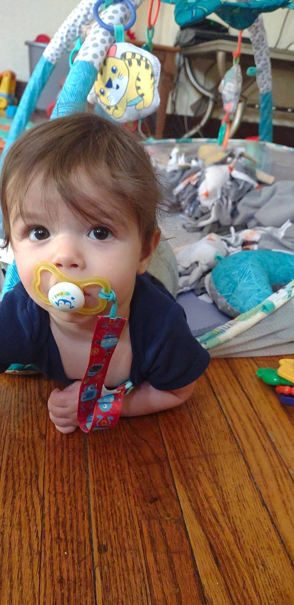 Rhythm is registered to the contest to win money with this photo: baby, baby_toddler_clothing, blue, chair, cheek, child, flooring, fun, happy, hardwood, person, plastic, play, sitting, t_shirt, textile, toddler, vacation, varnish, wood