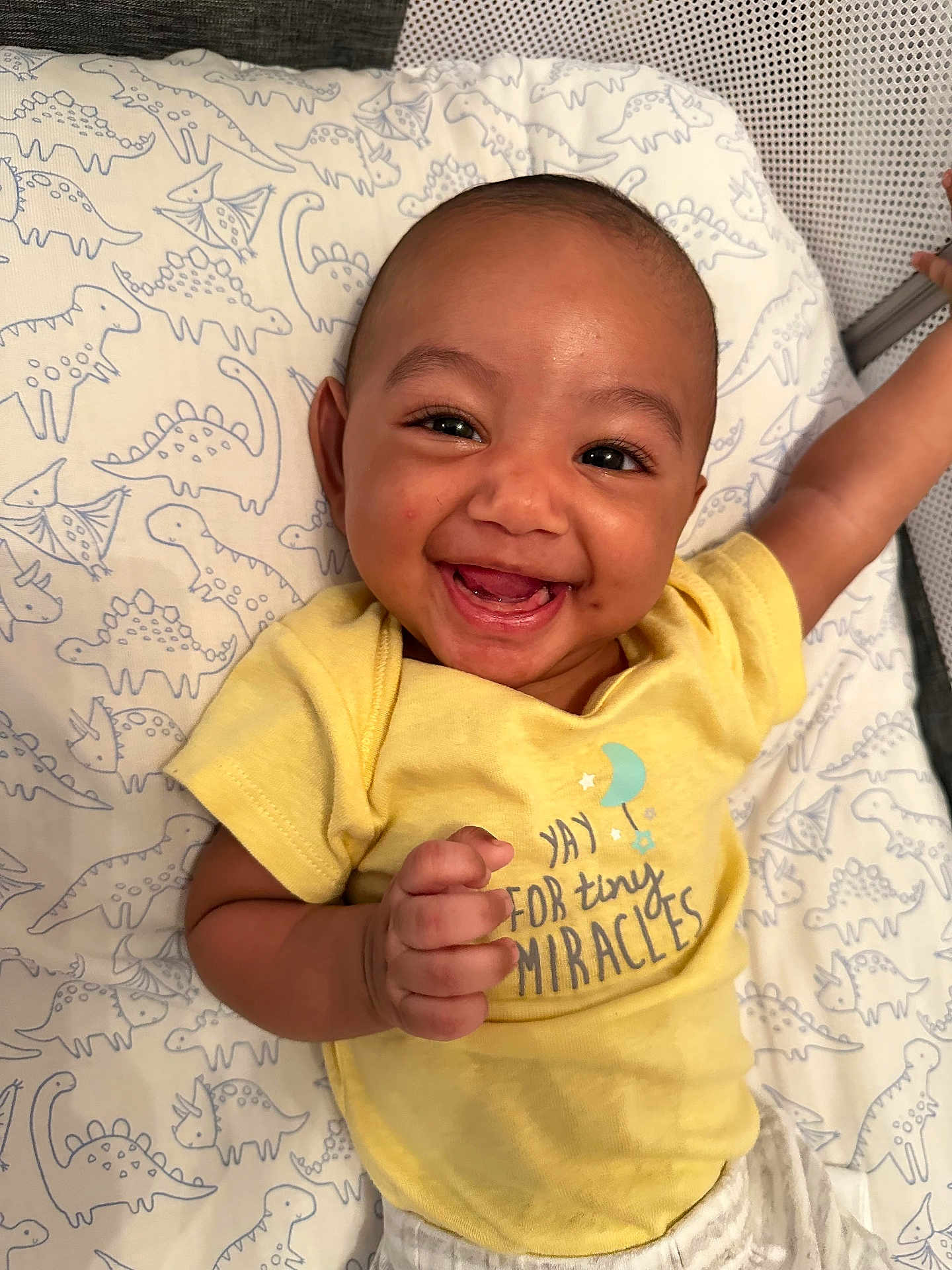 Troy joined the competition — help win amazing prizes! baby, smiling, yellow_shirt, dinosaur_pattern, blanket, happy, infant, cute, hand, face, lying_down, indoors, child, expression, toddler, portrait, clothing, person, skin, cheerful