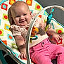 baby, smiling, pink_pants, baby_rocker, toys, colorful, indoor, child, cute, happy, infant, clothing, play, face, person, seat, relaxing, casual, childhood, comfort