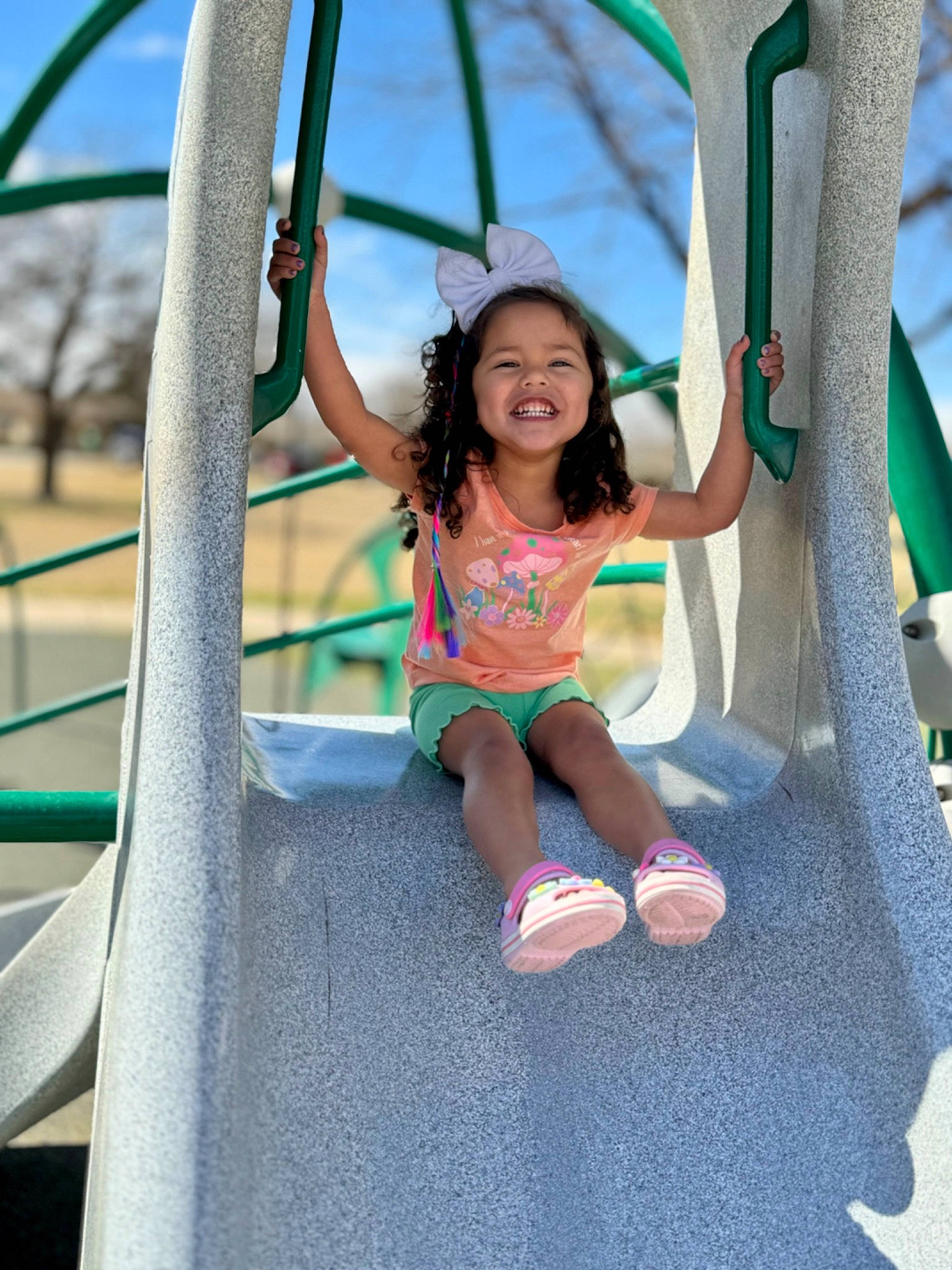 Camila Rae is registered to the contest to win money with this photo: aqua, azure, child, electric_blue, fun, green, happy, joy, leisure, outdoor_play_equipment, person, playground, public_space, recreation, shorts, sky, smile, summer, swing, t_shirt