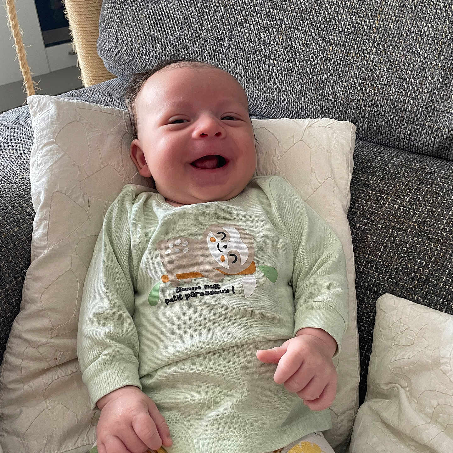 Harry participe au concours pour gagner de l'argent avec cette photo : baby, child, clothing, couch, cozy, cute, face, furniture, happy, home, indoors, infant, pajamas, person, pillows, portrait, relaxing, sitting, smiling, soft