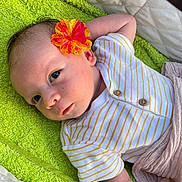 Harry a rejoint le concours — aidez-le/la à gagner de superbes lots ! baby, flower, striped_clothing, towel, infant, face, skin, head, eyes, arm, buttoned_onesie, yellow_stripes, pink_blanket, lying_down, curious_expression, soft_light, indoors, closeup, portrait, newborn