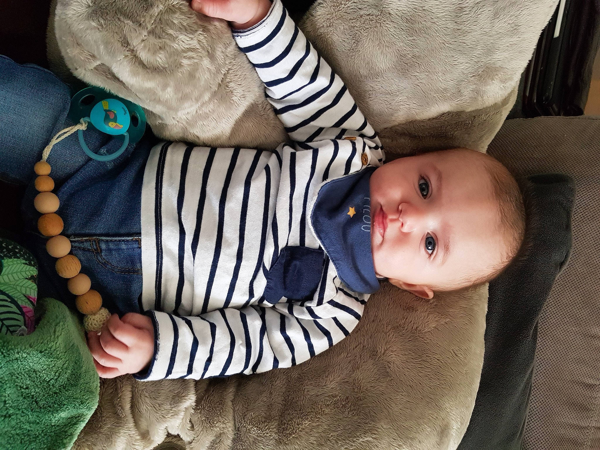 Lylio participe au concours pour gagner de l'argent avec cette photo : baby, baby_products, baby_toddler_clothing, child, comfort, electric_blue, fashion_accessory, finger, gesture, nail, pattern, person, product, sitting, sleeve, textile, toddler, wrist