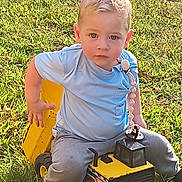 James joined the competition — help win amazing prizes! child, toddler, toy_truck, outdoor, grass, blue_shirt, grey_pants, sunlight, play, cute, face, eyes, person, young_child, daylight, nature, sitting, toy, yellow, casual_clothing