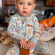 animal_print, blue_eyes, casual, child, clothing, curious, cute, expression, holding, home, indoor, jar, kitchen_counter, pajamas, portrait, preserves, sitting, toddler, wooden_cabinets, young_child