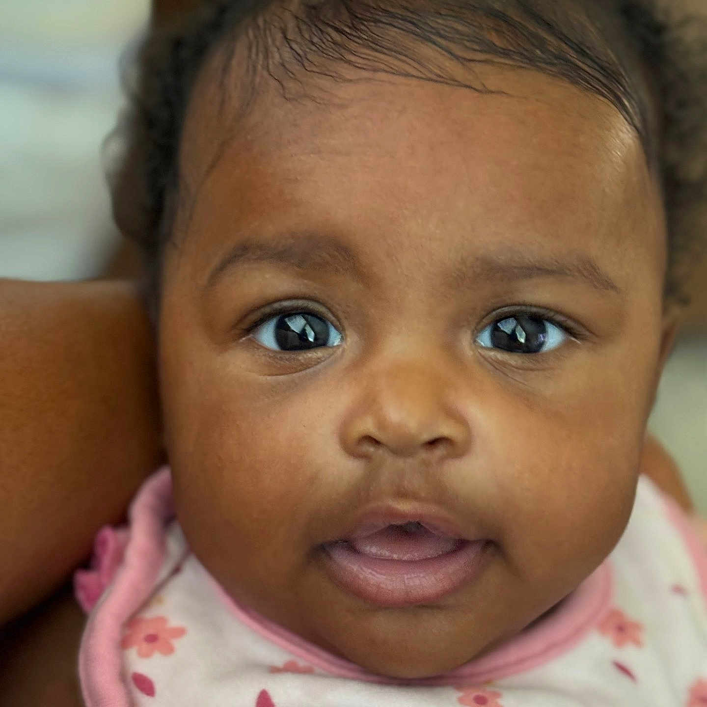 Daijah joined the competition — help win amazing prizes! adorable, baby, child, close_up, clothing, curly_hair, cute, expression, eyes, face, human, indoor, infant, mouth_open, person, pink_bib, portrait, skin, soft_lighting, young