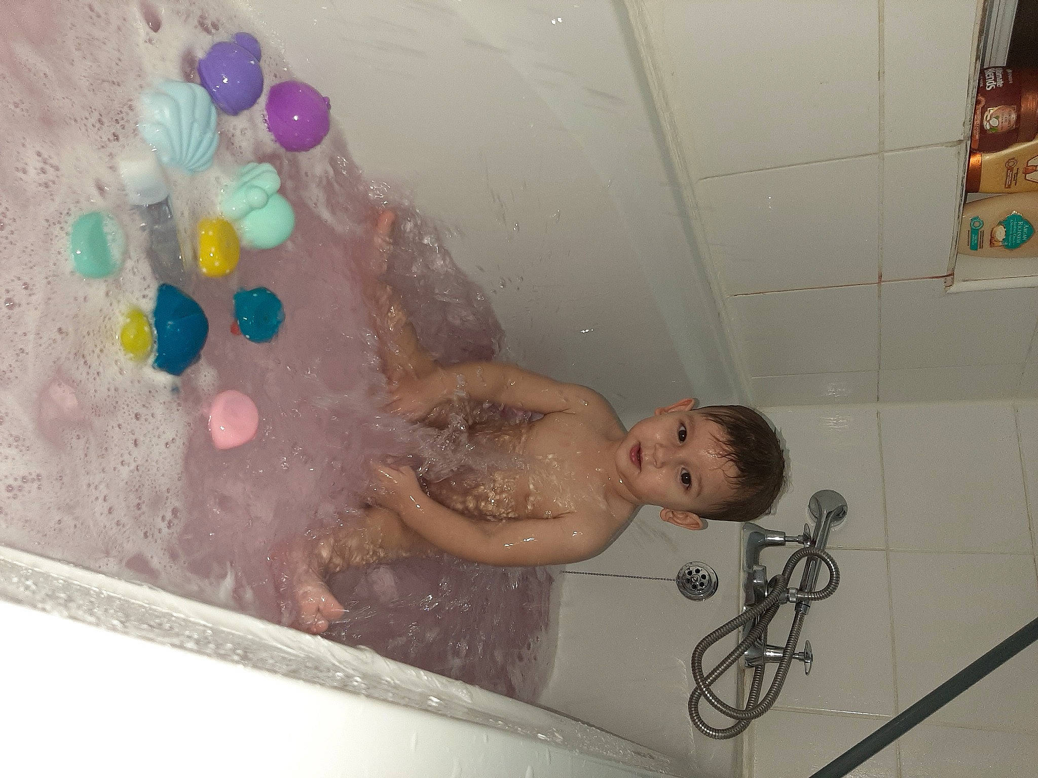 Nicholas is registered to the contest to win money with this photo: arm, bath_toy, bathing, bathroom, bathtub, chest, child, fluid, fun, happy, leisure, person, plumbing, plumbing_fixture, recreation, room, smile, swimwear, tap, toddler