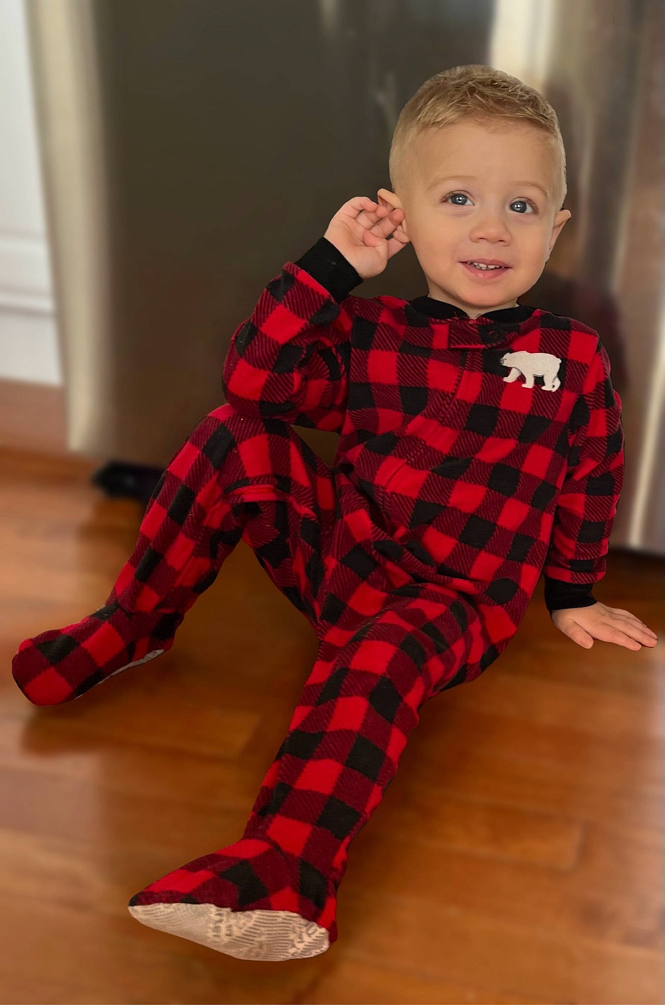 Colton is registered to the contest to win money with this photo: arm, baby_toddler_clothing, face, finger, floor, flooring, joint, joy, knee, leg, neck, outerwear, person, plaid, shoulder, sleeve, smile, tartan, textile, thigh