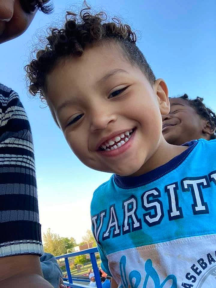 Logan is registered to the contest to win money with this photo: blue, daytime, eye, face, facial_expression, forehead, gesture, hairstyle, happy, joy, leisure, light, muscle, organ, person, photograph, sky, smile, social_group, sunlight