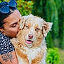 woman, dog, kiss, blue_eyes, fluffy, tattoo, outdoor, greenery, nature, affection, pet, happy, closeup, portrait, summer, casual, sunglasses, animal, love, friendship