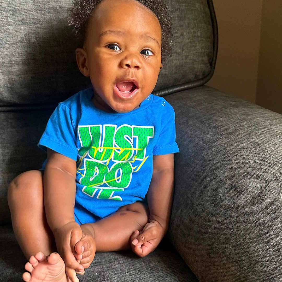 Makani joined the competition — help win amazing prizes! architecture, baby, building, chair, clothing, couch, cushion, face, furniture, happy, head, homedecor, indoors, livingroom, pants, person, photography, portrait, sitting, t_shirt