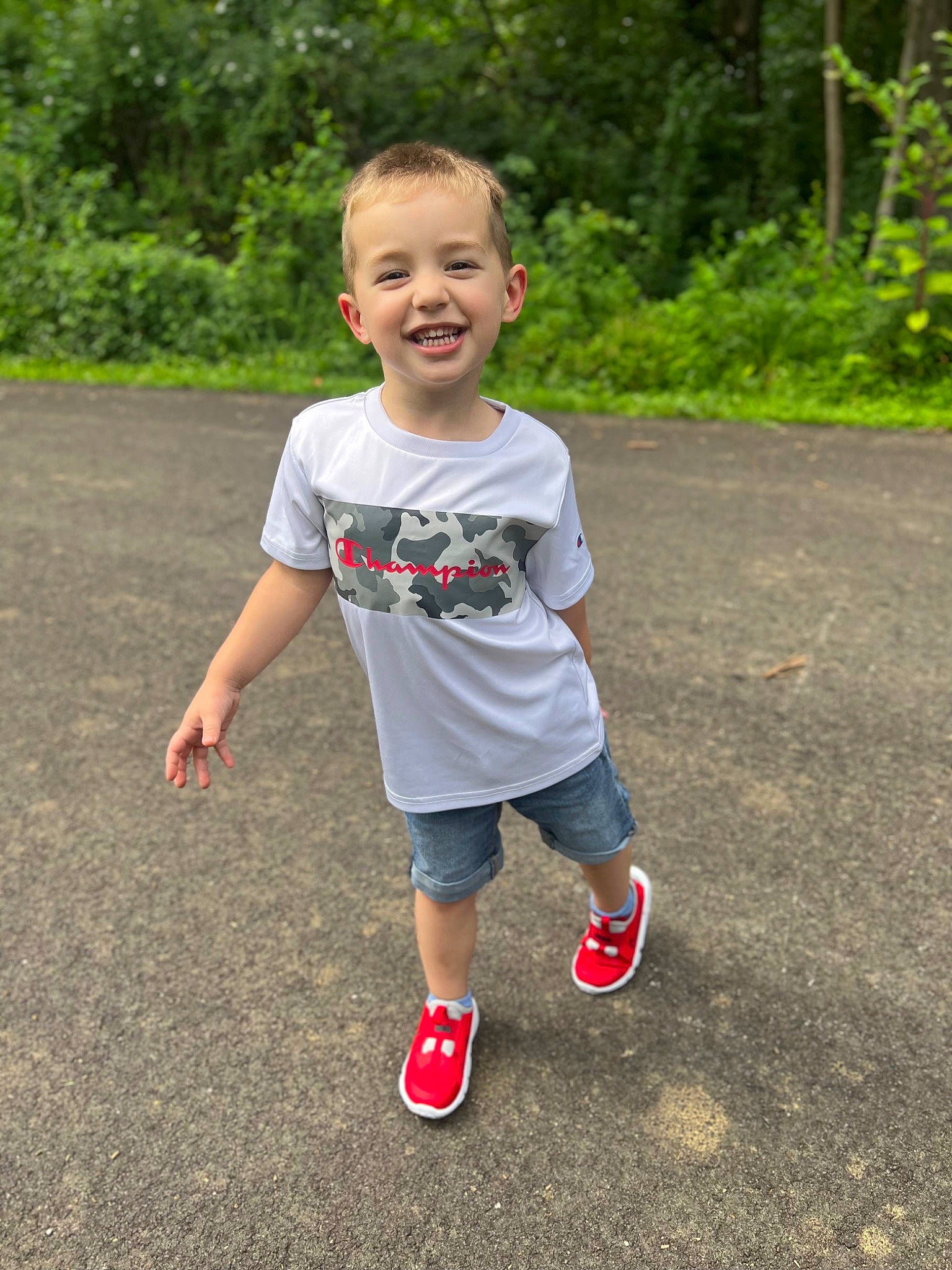 Atlas is registered to the contest to win money with this photo: asphalt, baby_toddler_clothing, eye, footwear, fun, grass, happy, head, human_body, joy, leaf, leisure, people_in_nature, person, plant, shorts, sleeve, smile, sneakers, t_shirt