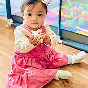 Layane participe au concours pour gagner de l'argent avec cette photo : baby, child, girl, pink_dress, headband, toy, brush, floor, indoor, playpen, colorful, curious, sitting, cute, portrait, young_child, wooden_floor, happy, infant, soft_lighting