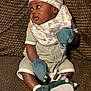 Ethan is registered to the contest to win money with this photo: baby, infant, child, onesie, mittens, slippers, bib, hat, couch, texture, brown, seated, cute, looking_sideways, indoor, soft_lighting, plush, comfortable, small, adorable