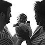 Amalyah participe au concours pour gagner de l'argent avec cette photo : baby, newborn, family, black_and_white, portrait, smile, mother, father, striped_clothing, headband, holding, love, happiness, tenderness, hands, people, indoor, closeup, candid, togetherness