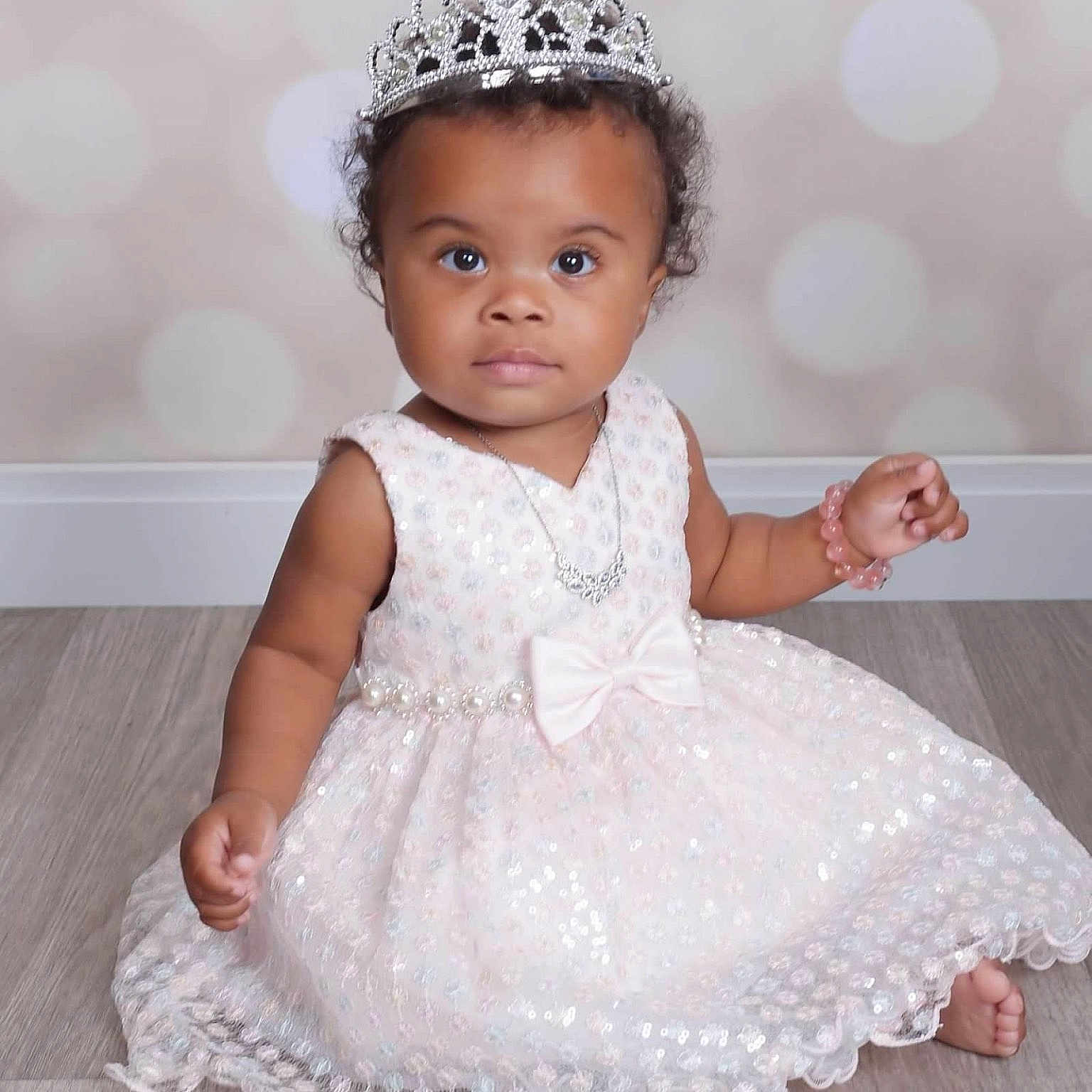 Paris is registered to the contest to win money with this photo: accessories, baby, clothing, crown, diamond, dress, eveningdress, face, formalwear, gemstone, head, jewelry, necklace, person, photography, portrait, sitting, sleeve, standing, tiara