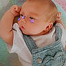 arm, baby, blanket, butterfly_stickers, cheeks, child, colorful, cute, denim_overalls, expression, face, fuzzy, head, heart_patch, indoors, infant, lying_down, skin, white_shirt, young
