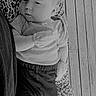 baby, black_and_white, blanket, calm, clothing, cute, date_overlay, digital_clock, floor, indoor, infant, mittens, pattern, person, portrait, resting, sleepy, time_overlay, wooden_floor, young_child