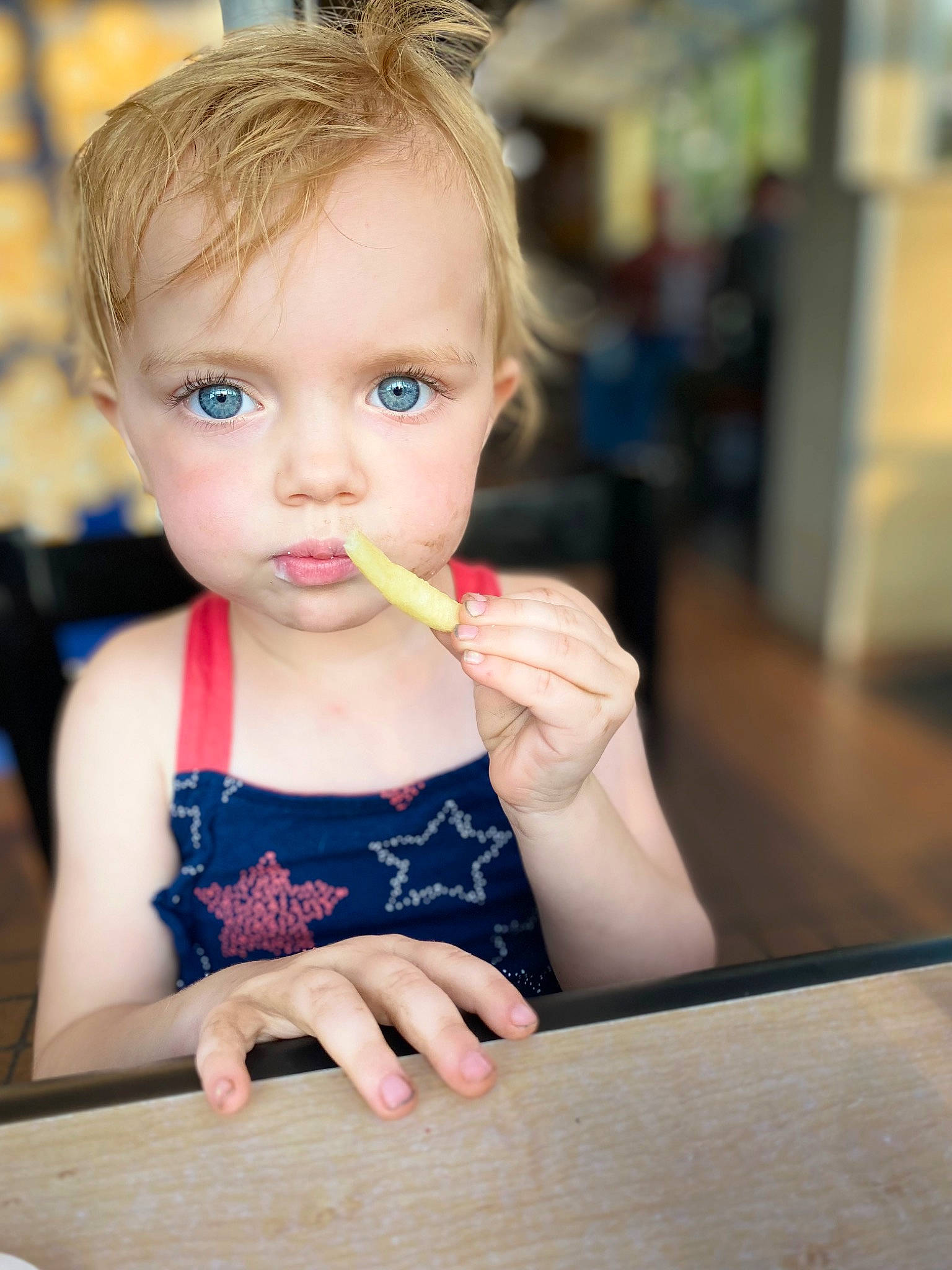 Natalie is registered to the contest to win money with this photo: baby, blond, cheek, child, desk, eyebrow, eyelash, finger, fun, hairstyle, hand, happy, lip, nose, person, sitting, skin, sweetness, table, tableware