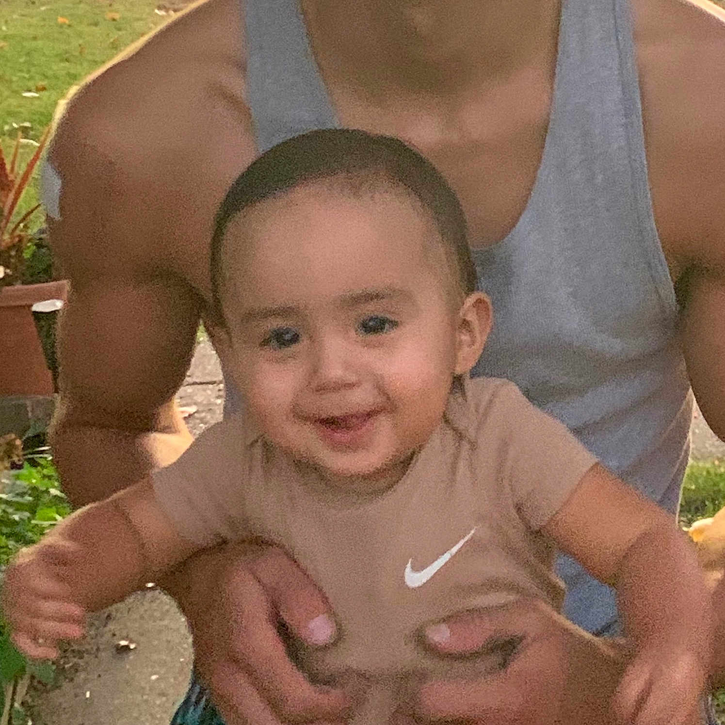 Trevon Gibbons Jr joined the competition — help win amazing prizes! adult, baby, beige_shirt, child, family, grass, greenery, hands, happy, muscular, nature, nike_logo, outdoor, person, plants, portrait, potted_plant, smiling, tank_top, toddler