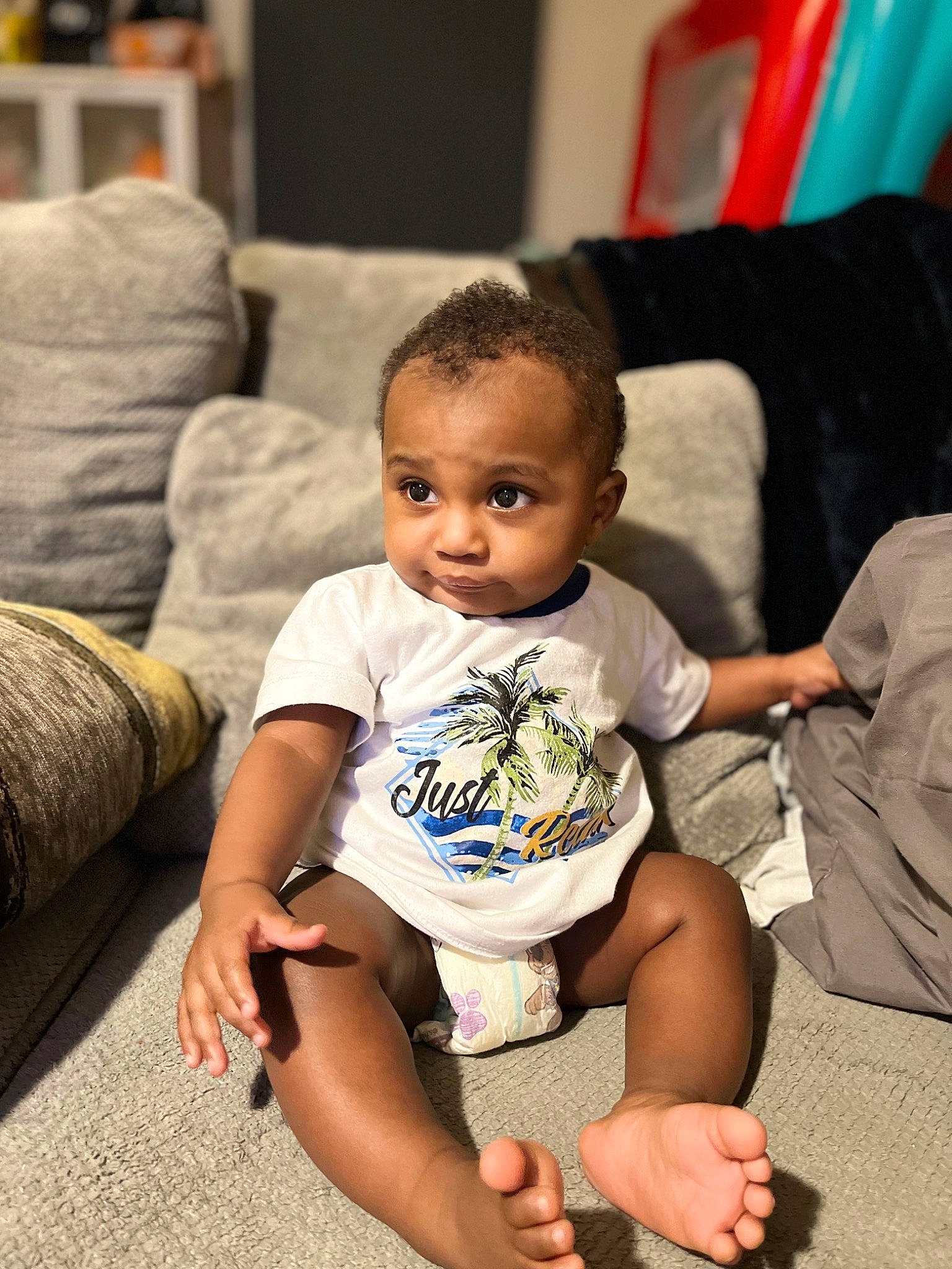 Messiah is registered to the contest to win money with this photo: baby, baby_toddler_clothing, cheek, child, comfort, couch, eye, face, flooring, fun, hairstyle, happy, head, human_leg, people, person, skin, smile, thigh, toddler