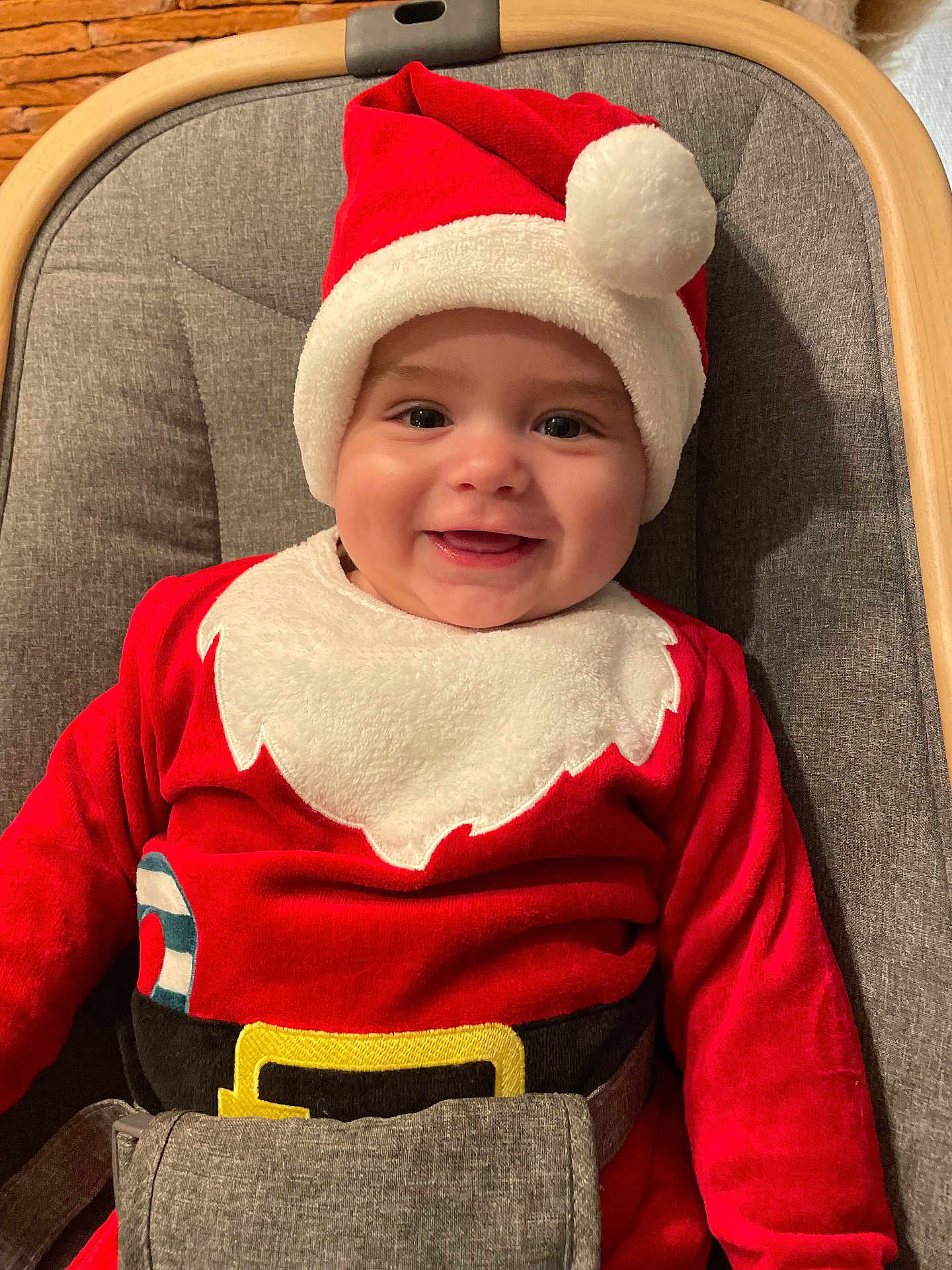 Louis a rejoint le concours — aidez-le/la à gagner de superbes lots ! baby, infant, smiling, santa_hat, christmas_outfit, red_clothing, white_trim, baby_chair, cushion, wooden_frame, happy, face, child, holiday, festive, indoors, seat_belt, portrait, cute, celebration