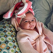 Ariya is registered to the contest to win money with this photo: baby, child, towel, bathrobe, pillow, pattern, face, headwear, indoor, cute, infant, soft, comfort, relaxing, expression, portrait, person, smile, skin, cozy