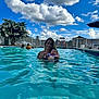 woman, baby, pool, water, swimming, sky, clouds, outdoor, fence, people, summer, relaxation, family, swimsuit, playground, umbrella, daylight, nature, recreation, leisure