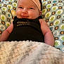 Ariya joined the competition — help win amazing prizes! baby, headband, smile, blanket, cushion, pattern, infant, clothing, face, skin, cheeks, person, indoors, comfort, resting, cute, young_child, apparel, soft, portrait
