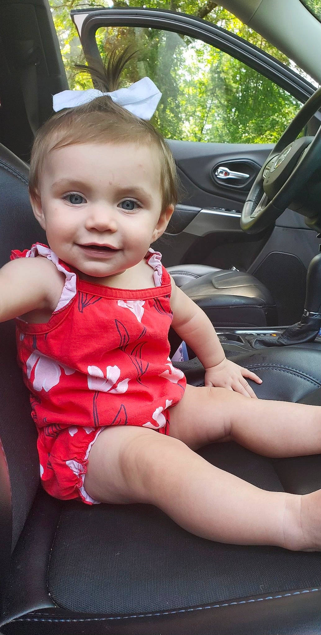 Norah is registered to the contest to win money with this photo: baby, baby_toddler_clothing, beauty, car, car_seat_cover, cool, facial_expression, hairstyle, happy, joy, leg, motor_vehicle, person, personal_luxury_car, pink, plant, skin, smile, steering_wheel, thigh