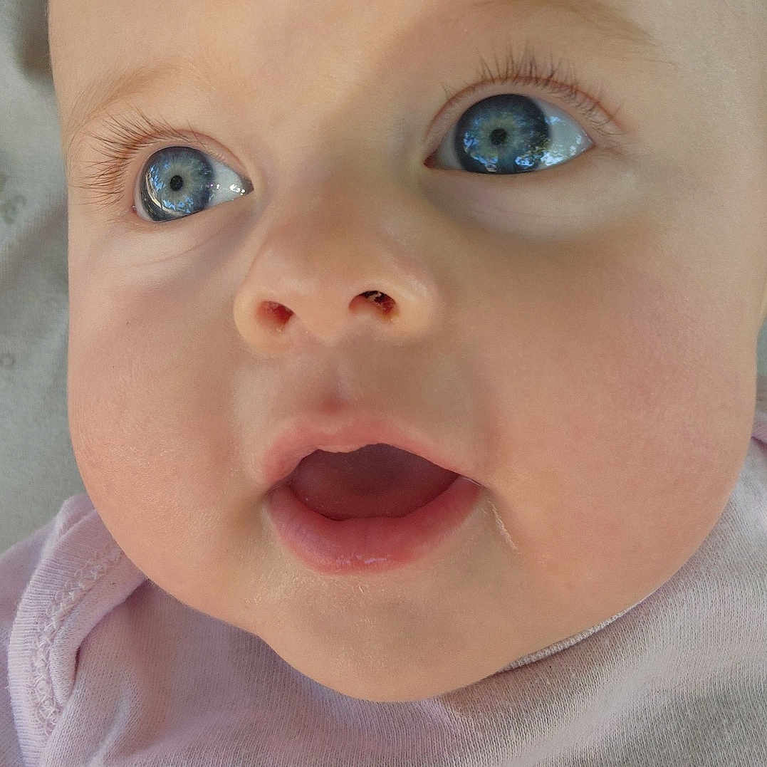 Madalynn is registered to the contest to win money with this photo: apparel, baby, blue_eyes, child, chubby_cheeks, close_up, curious, cute, drool, expression, eyelashes, face, head, infant, mouth_open, nose, person, pink_shirt, skin, text_on_clothing
