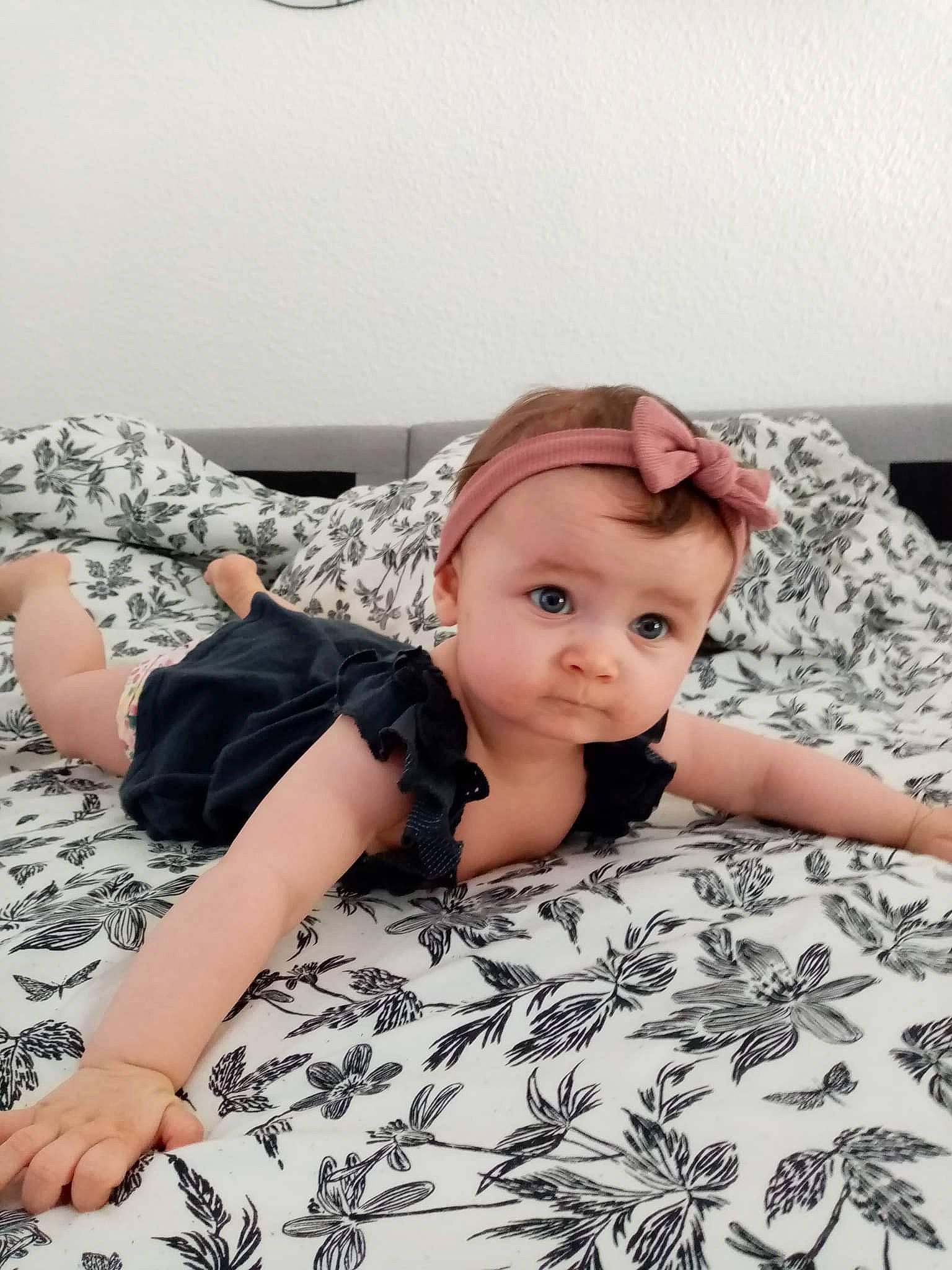 Giulia participe au concours pour gagner de l'argent avec cette photo : baby, baby_toddler_clothing, bedding, child, comfort, flash_photography, floor, flooring, grey, happy, head, linens, pattern, person, pink, shoulder, sitting, sleeve, textile, toddler