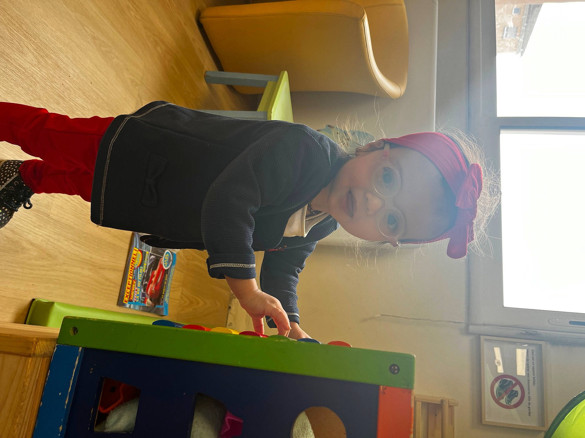 Nour participe au concours pour gagner de l'argent avec cette photo : child, flooring, fun, green, hat, person, play, room, t_shirt, toddler, visual_arts, window, wood, yellow