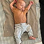 baby, sleeping, blanket, striped_pants, brown_shirt, infant, cozy, soft_texture, peaceful, indoors, child, cute, resting, relaxed, floor, striped_blanket, toddler, skin, head, foot