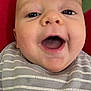 Lincoln is registered to the contest to win money with this photo: baby, smiling, face, closeup, infant, striped_clothing, mouth_open, happy, cheeks, eyes, person, indoor, red_background, television, blurred_background, head, skin, baby_clothes, child, portrait