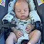 baby, sleeping, car_seat, onesie, dinosaur_pattern, infant, child, straps, warning_label, cute, peaceful, foot, hand, paciifier, seatbelt, rest, young, infancy, safety, comfort